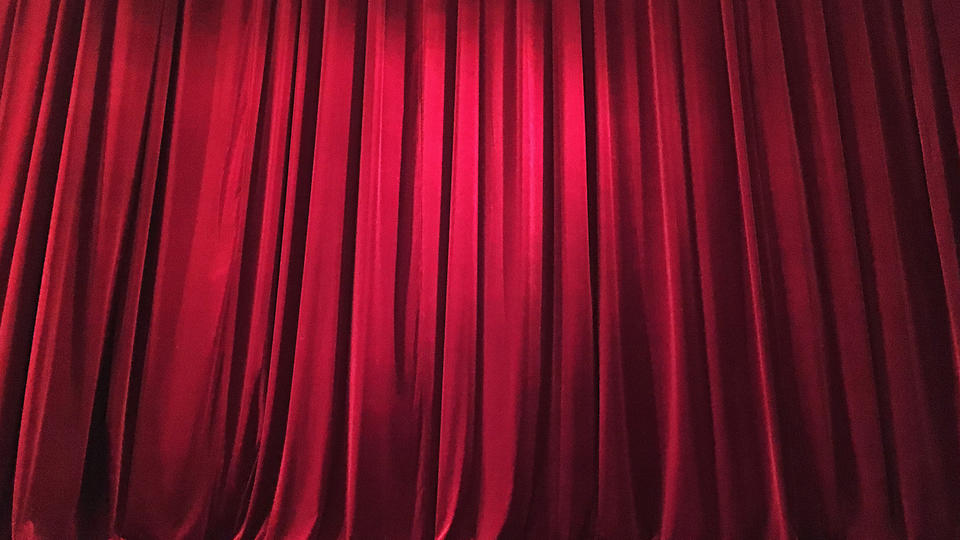 Theatre curtain closed on stage.