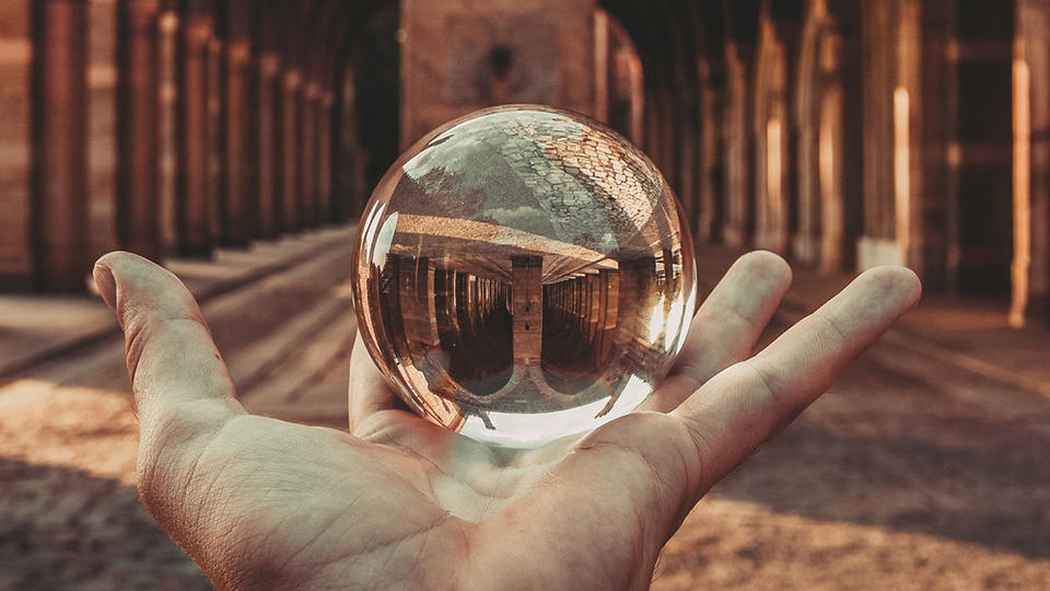 Holding a crystal ball in front of a hallway 