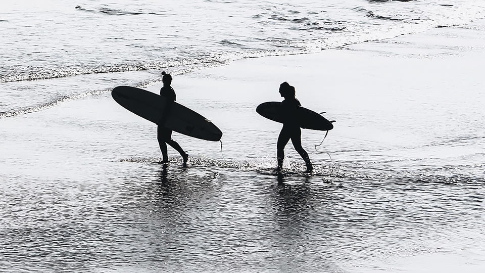 Two women going out to surf