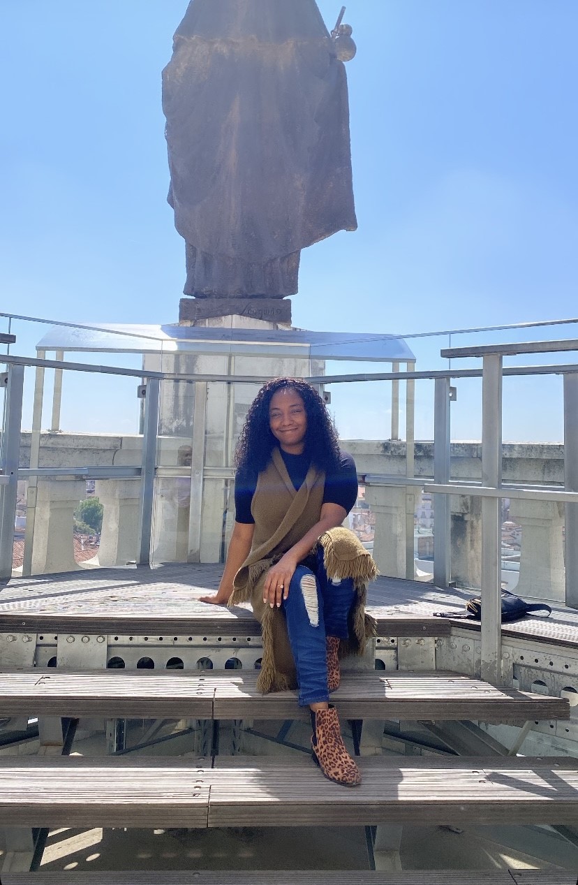 Shyla Finley sitting on stairs outside in front of statue