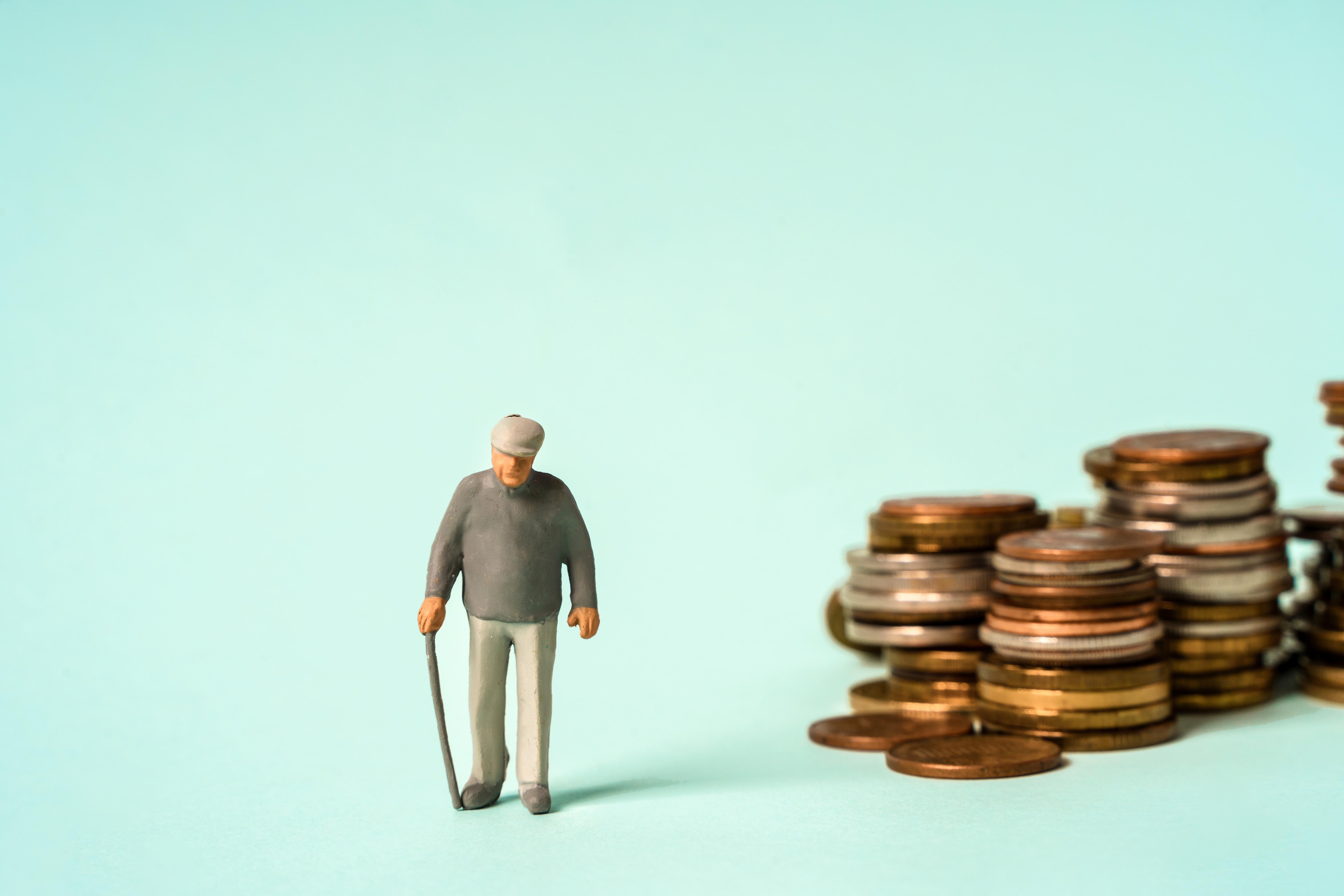 Older man with cane in front of pile of pennies