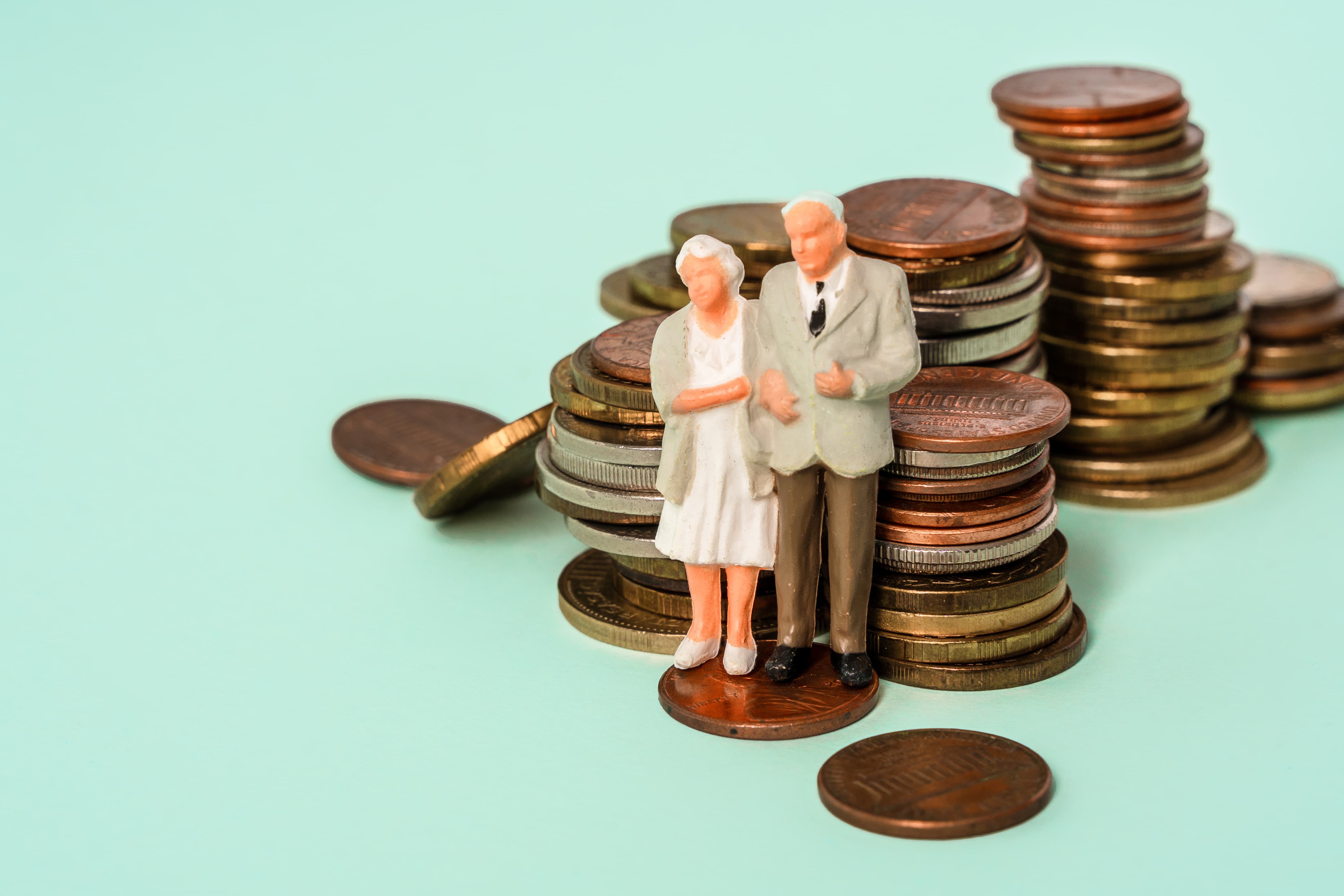 Figurines of older couple on stack of coins