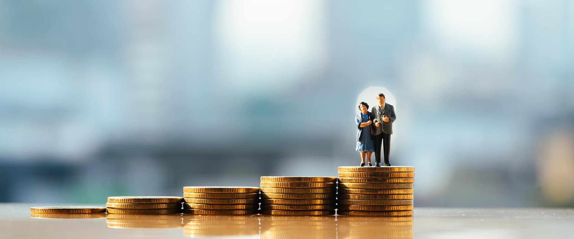 Figurines of older couple on stack of coins