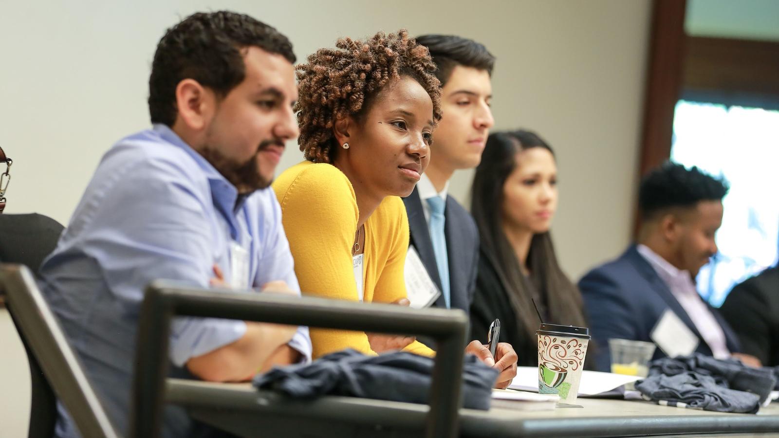 Group of students in class with female student in yellow sweater