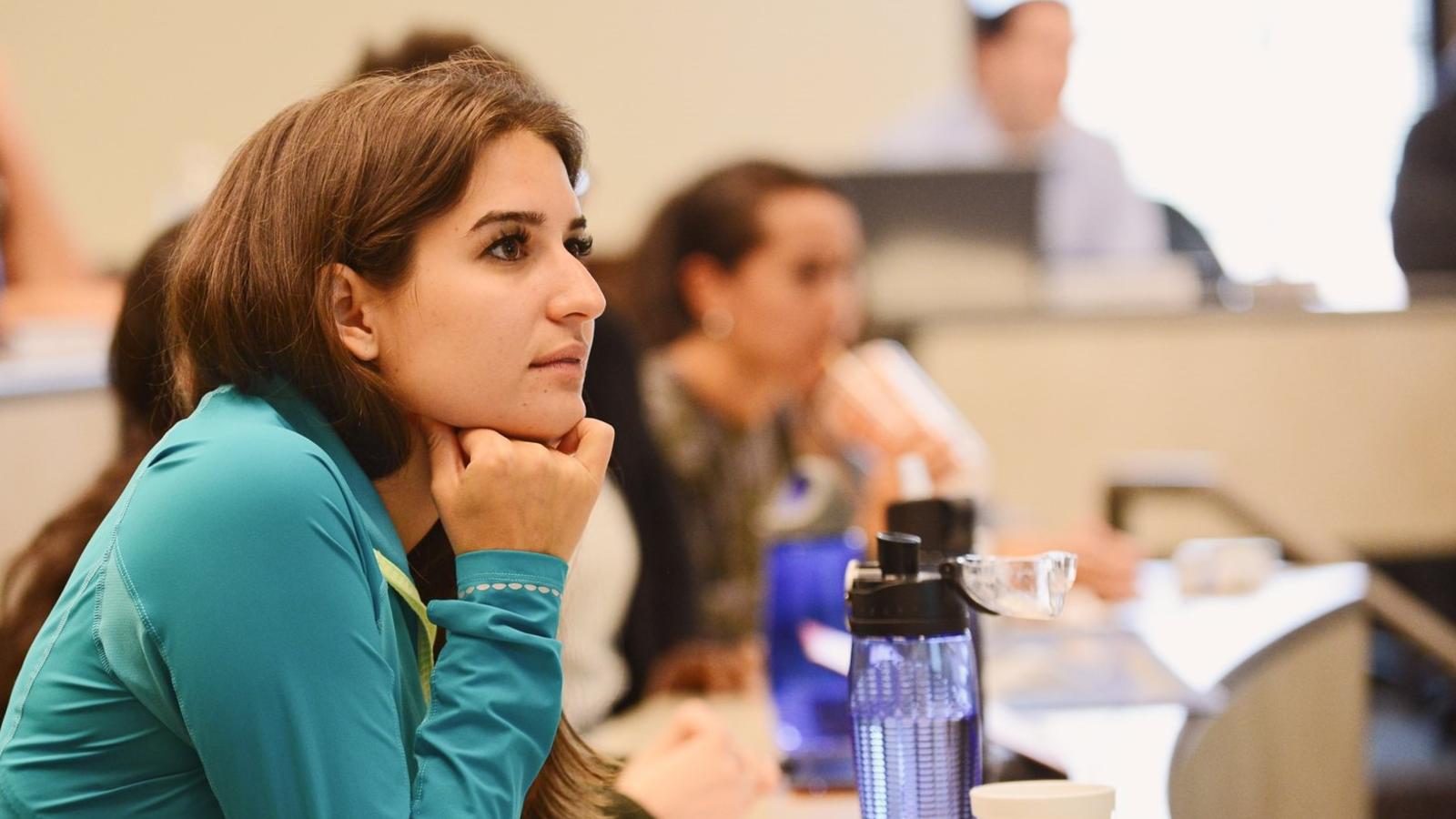 Female student in blue shirt engaging in class