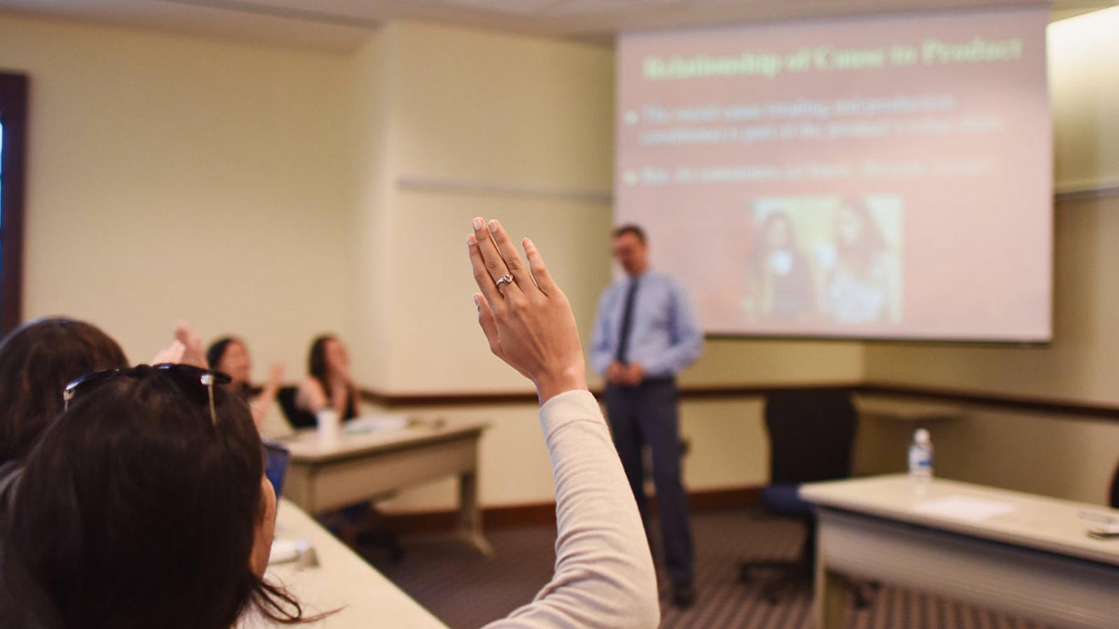 Student raising hand in classroom