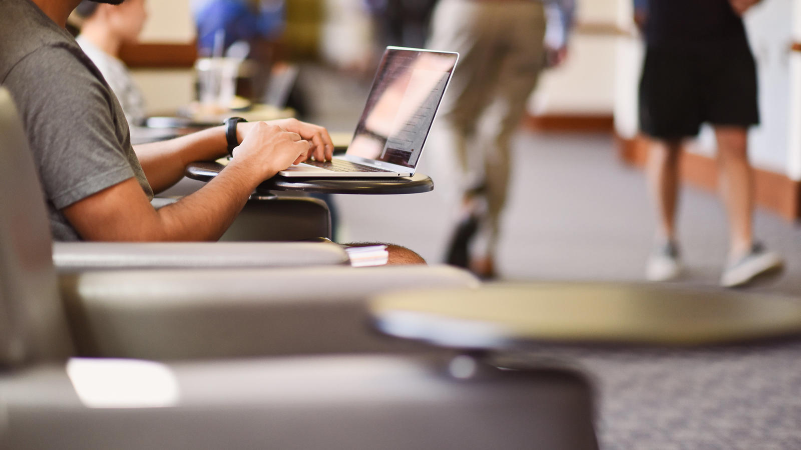 Student on computer in hallway