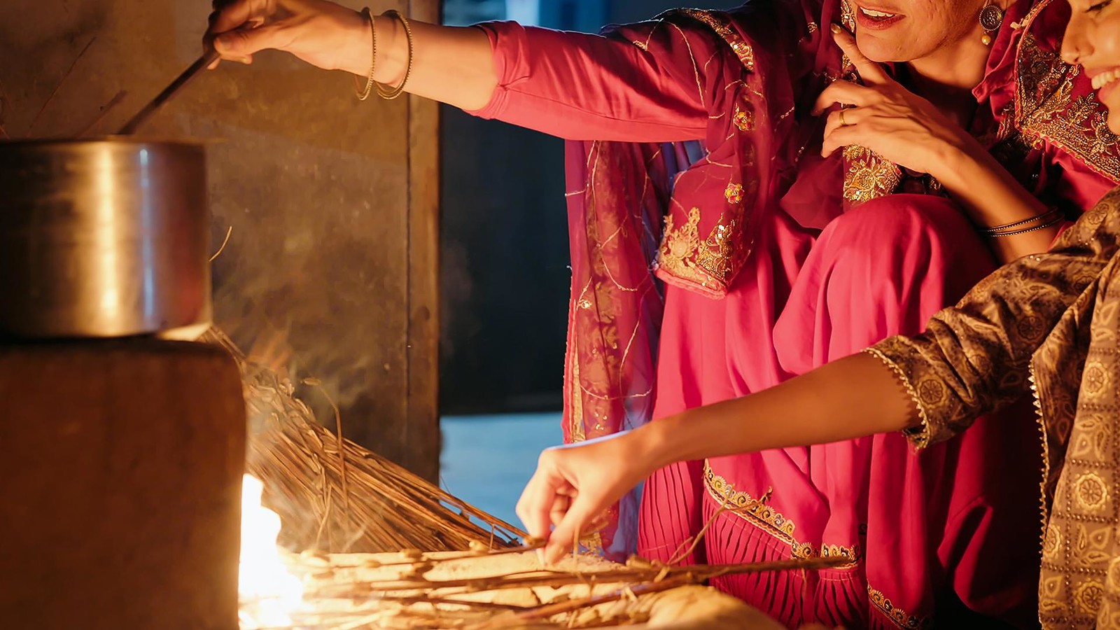 Two women cooking over a fire