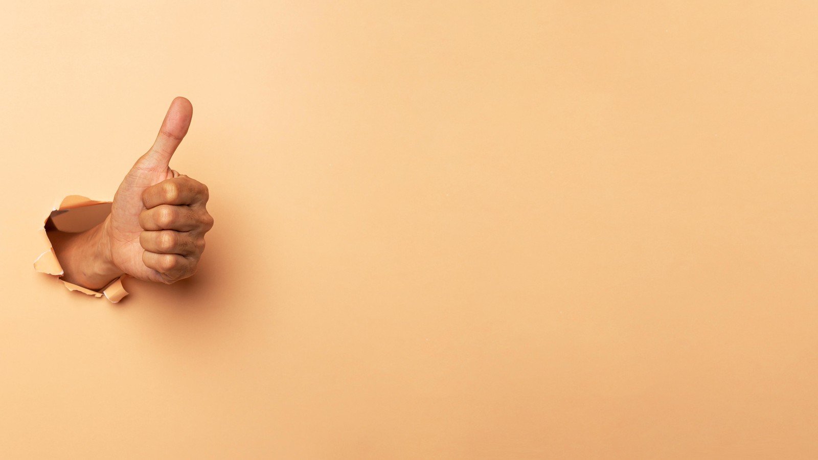 Thumbs-up hand punches through wall