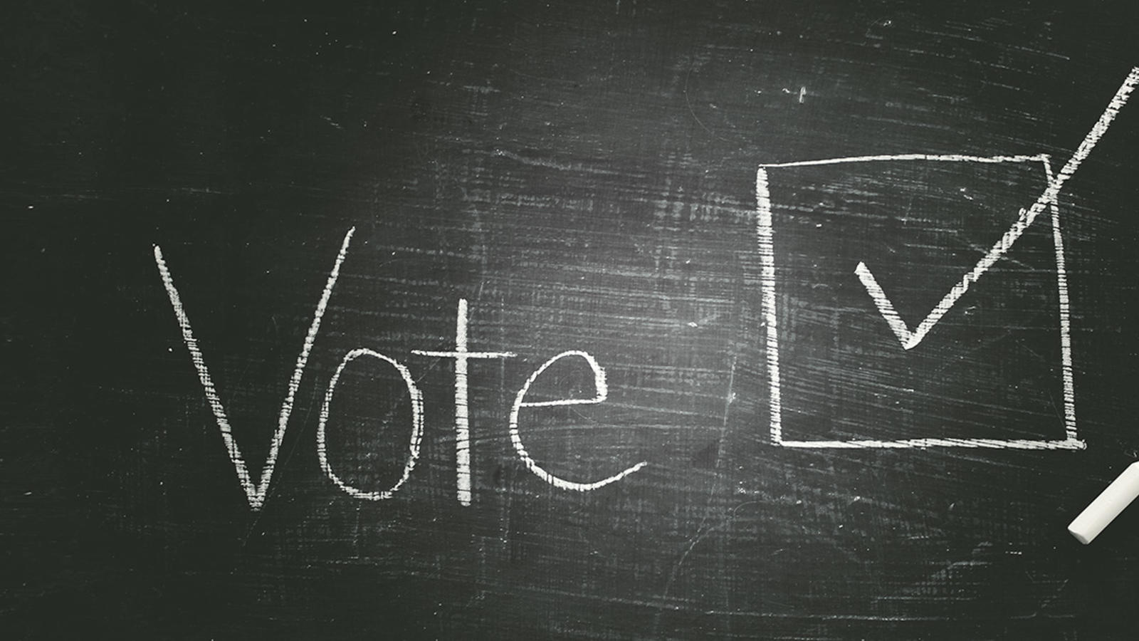 Chalk board that reads "Vote" with a checked box next to it.