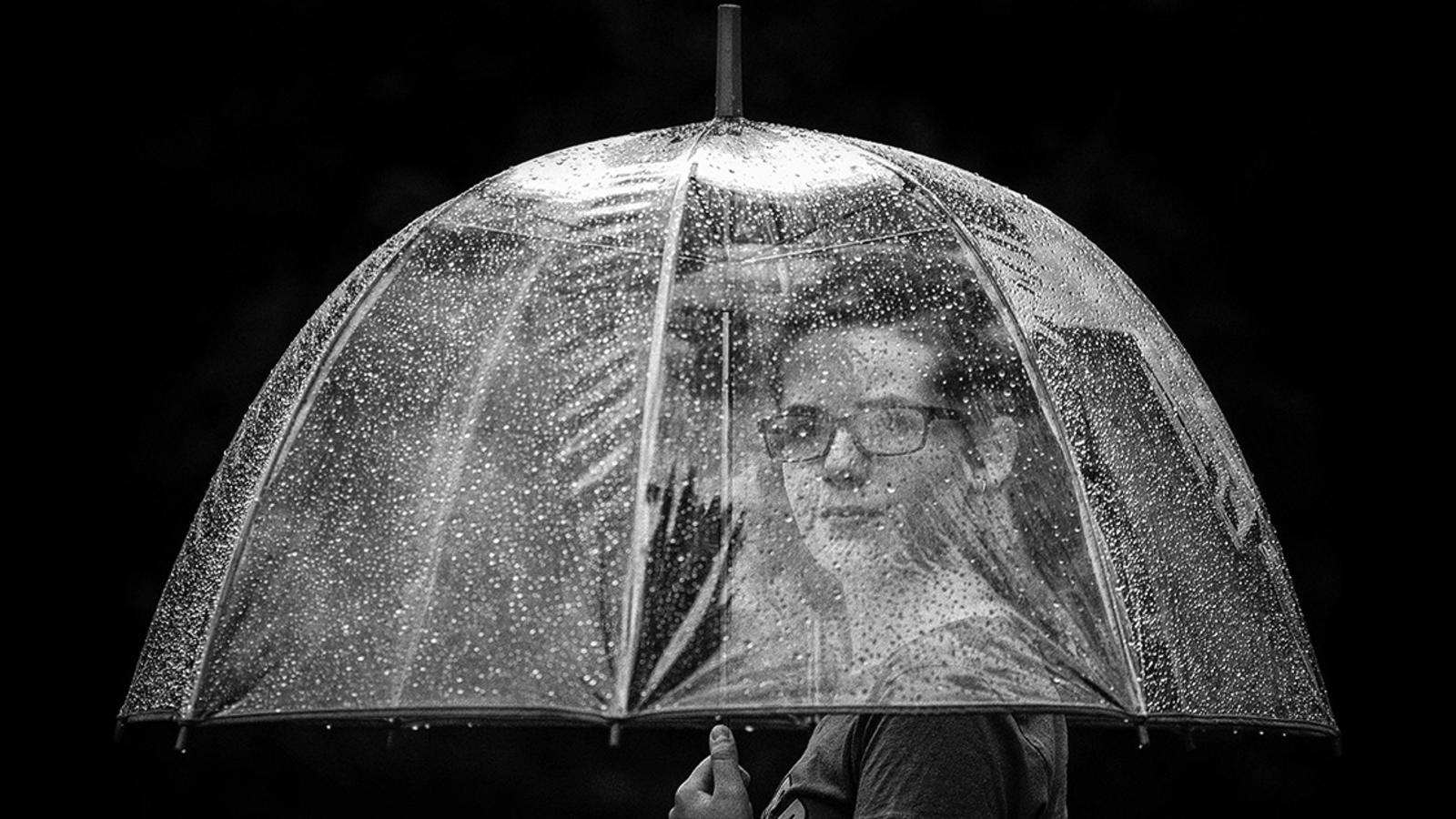 Woman underneath a clear umbrella