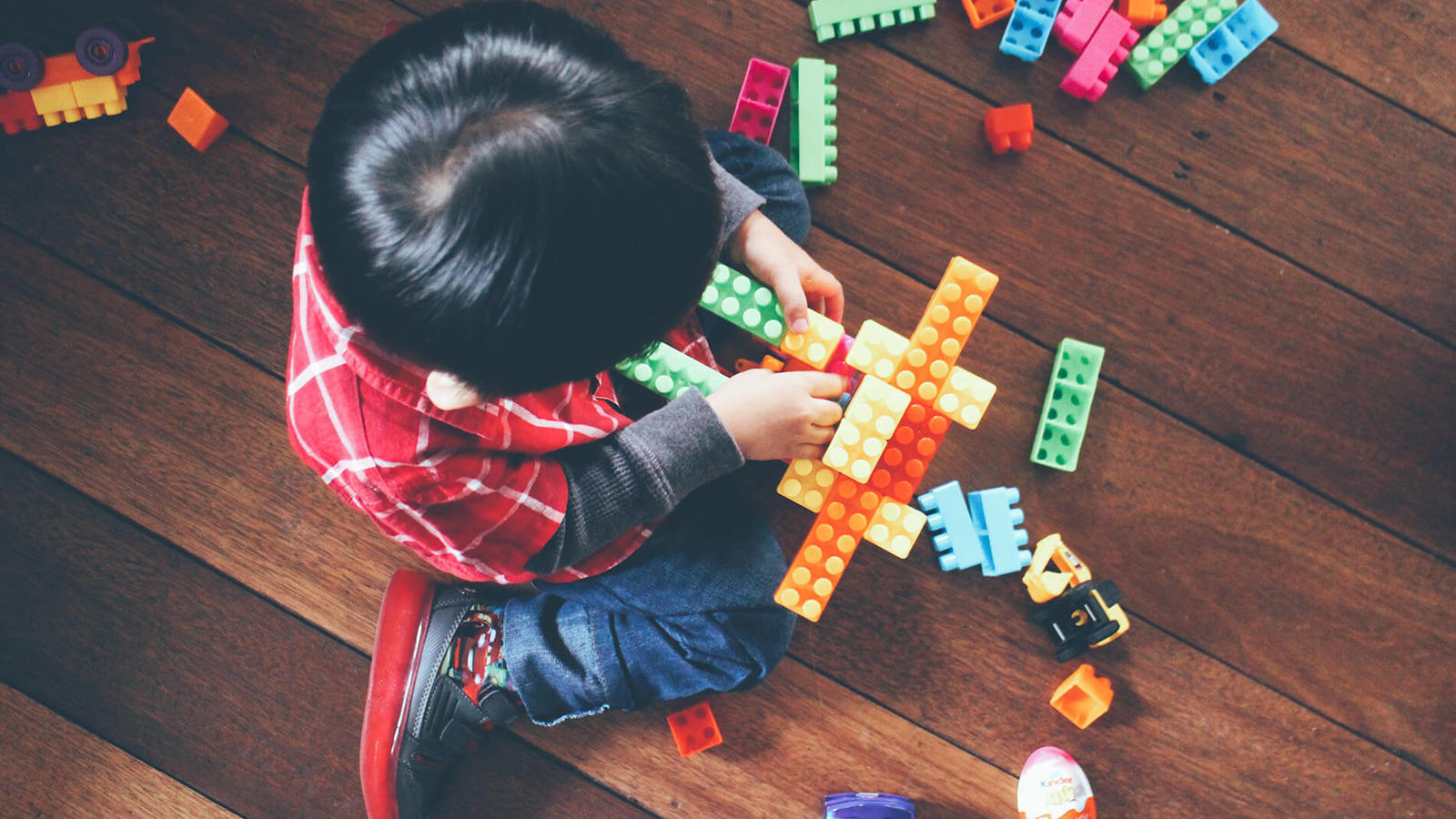 Young boy playing with building blocks.
