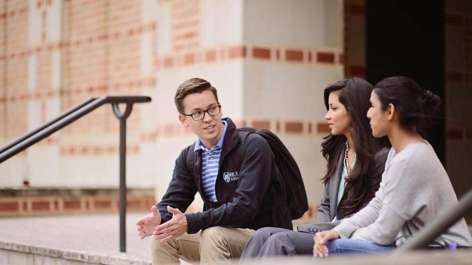 One male and two female students talking on steps outside of McNair Hall