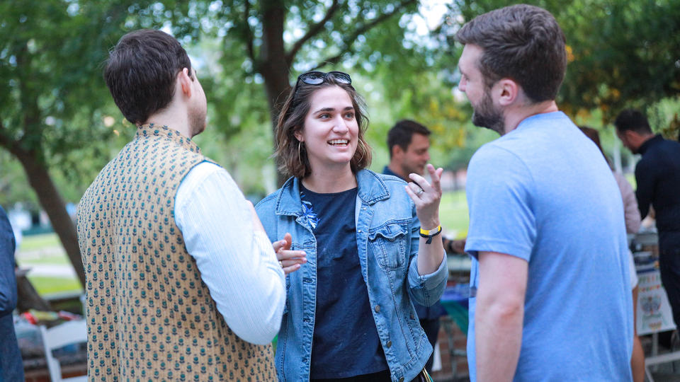 Female telling story to two males outside