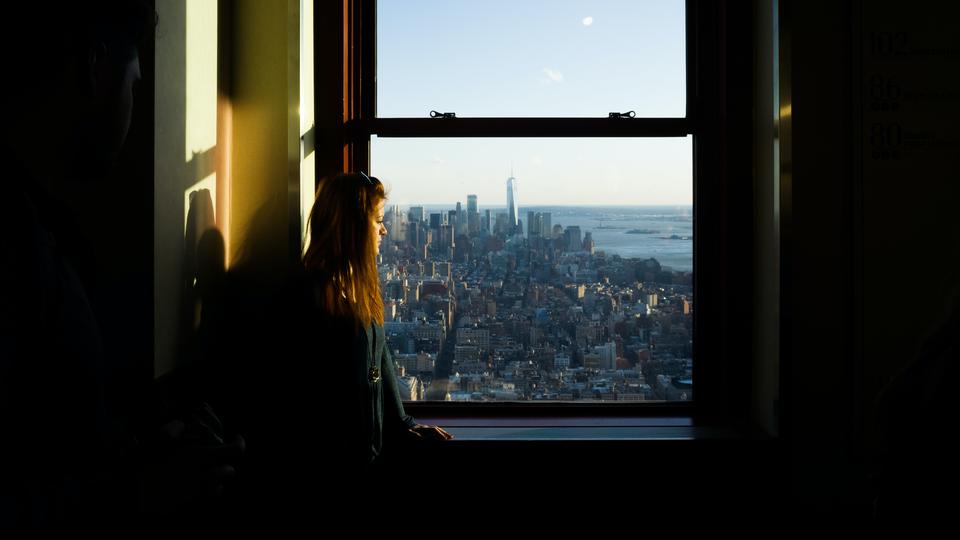 Hardship presents opportunity - woman looking out window over city