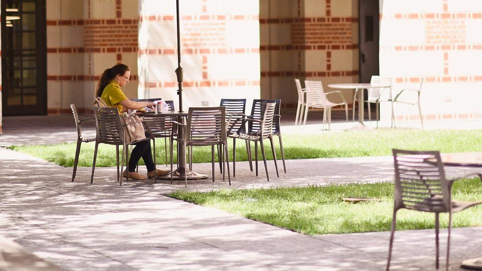 female student working on computer outside