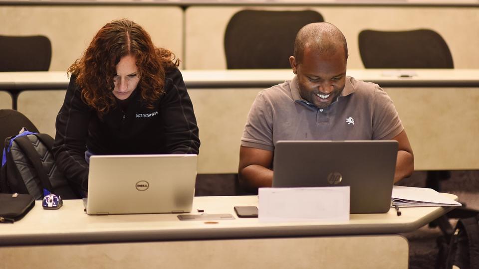 man and woman working on computers