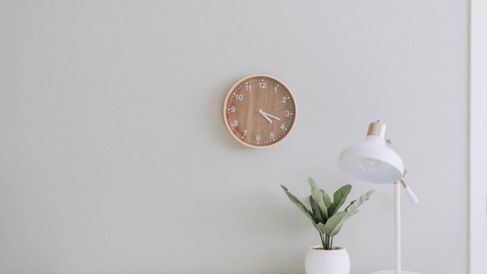Brown clock on white wall