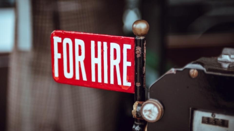 Red sign with the words "for hire" in white text