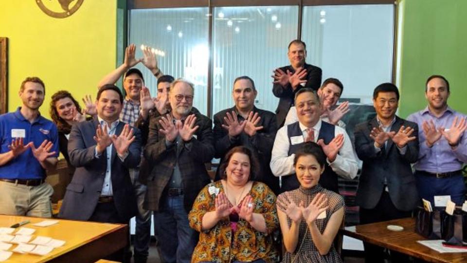 Group of alumni doing "owl hands" at Southern Yankee Beer Company