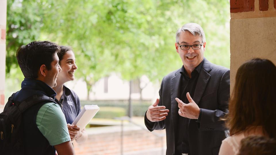 Professor talking to students outside