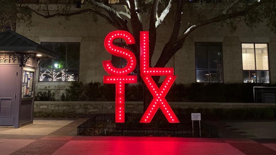 Nighttime picture of large red illuminated "SLTX"