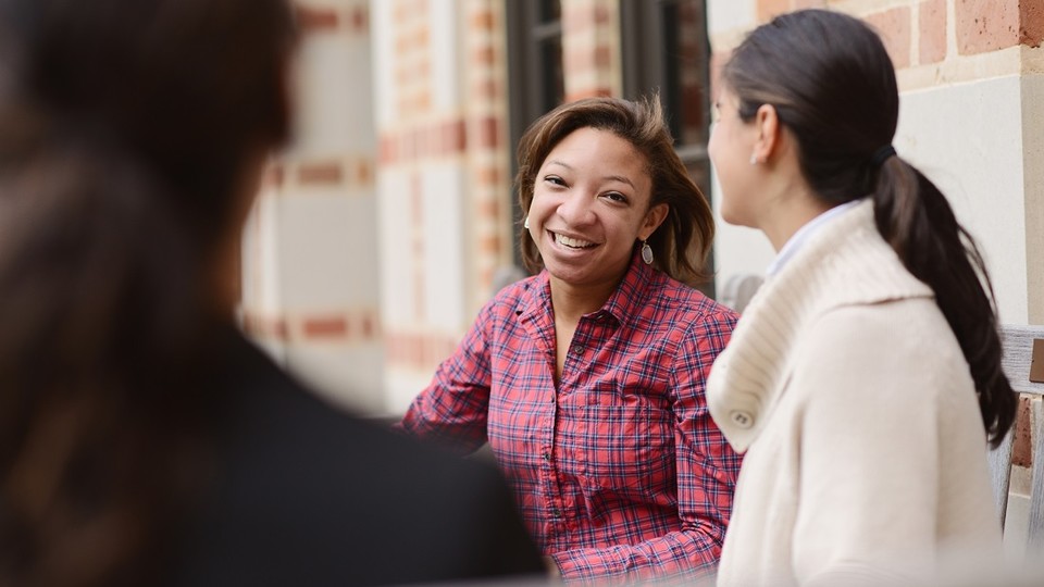 Female Rice MBA students conversing outside McNair Hall