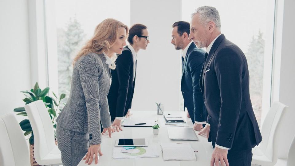 Business officials staring across table