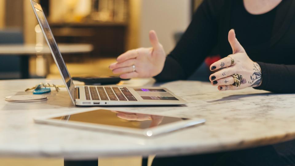 Photo of woman on remote meeting with tattoos