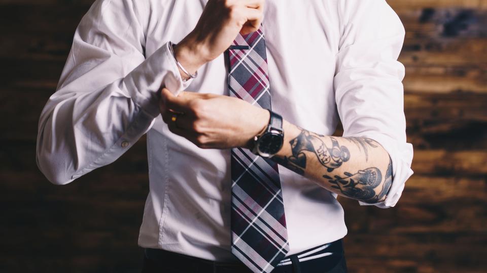 Tattooed Employee Fixing Shirt Cuff