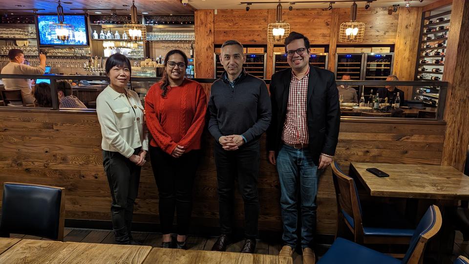 Group of three alumni and Dean Peter Rodriguez standing in a line