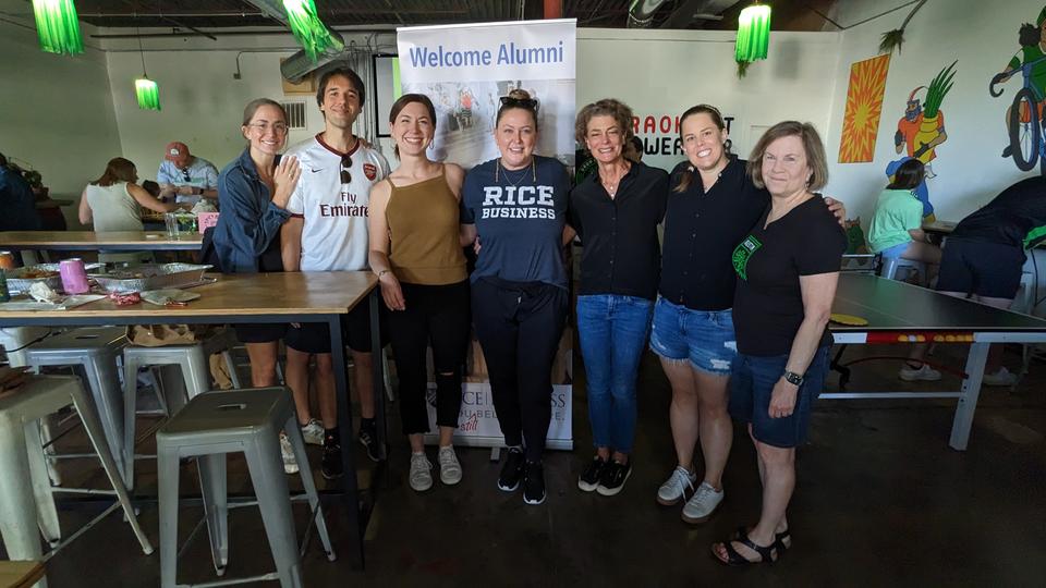 A group of alumni standing and smiling in a line