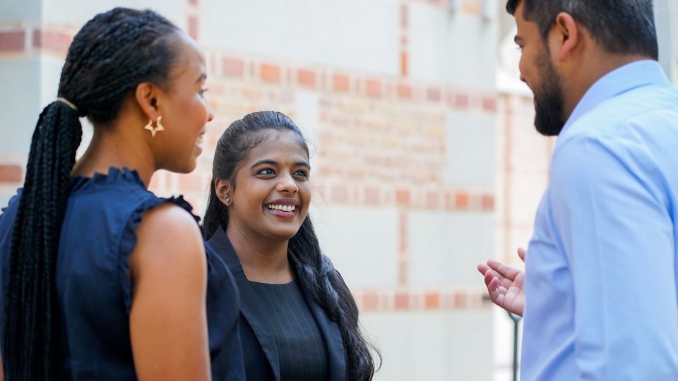 three students talking outside