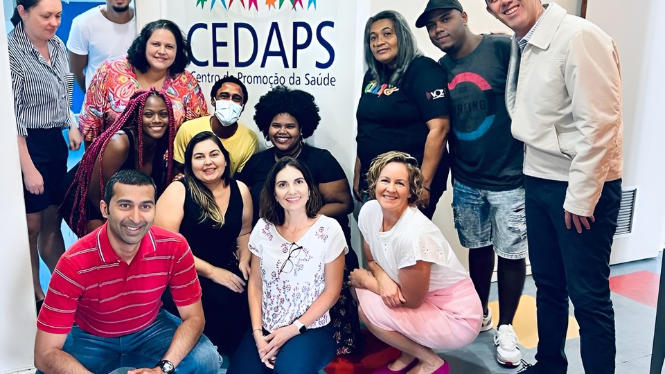 A group of people gather around a hall banner for CEDAPS