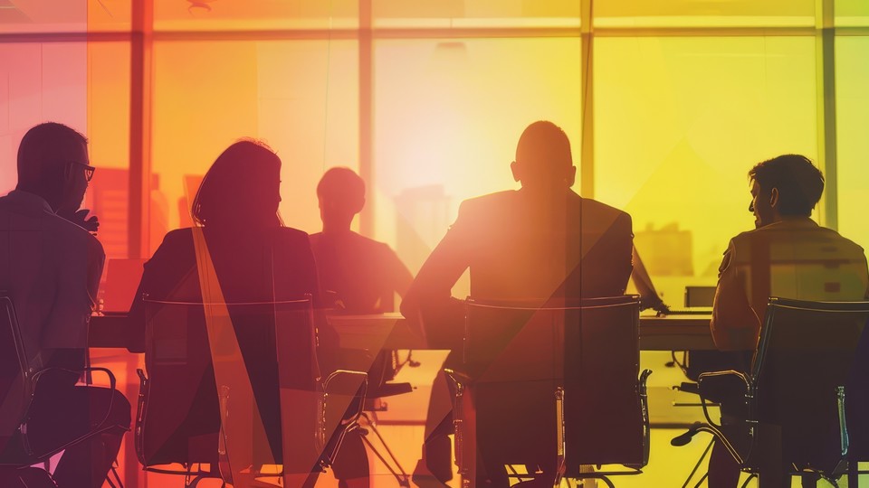 People sitting in a boardroom behind rainbow gradient glass.