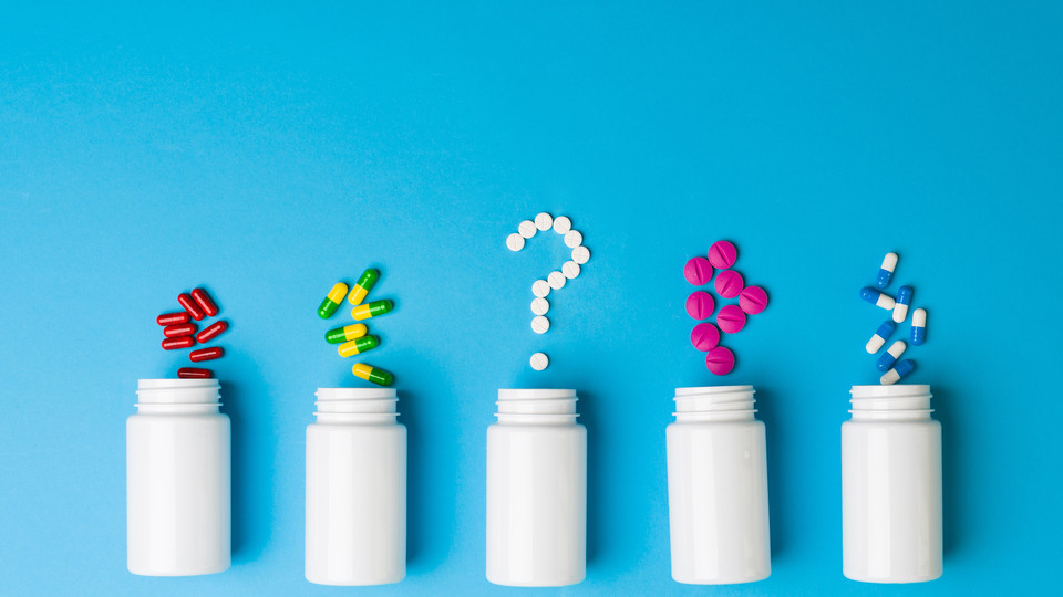 Prescription drugs, pills in shape of question mark