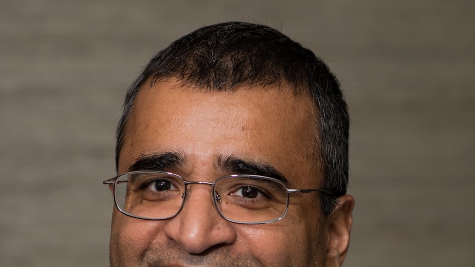 Vikas Mittal smiling in a plaid shirt. 