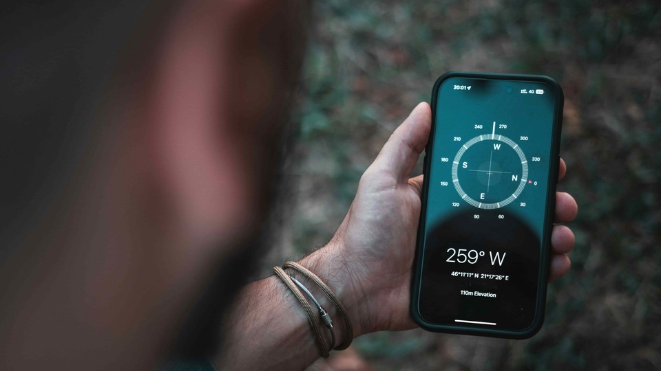 Man looks at compass app on his phone