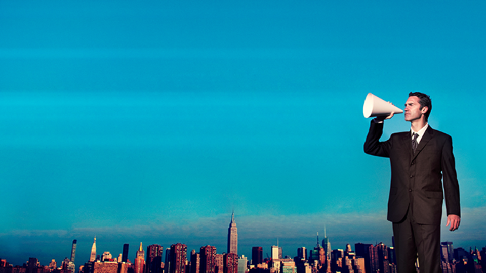Man holding megaphone against city skyline background