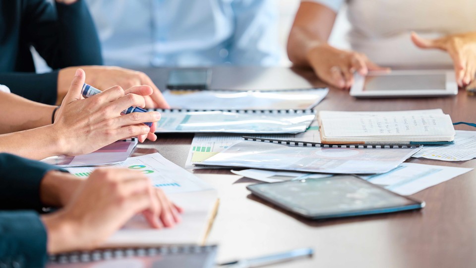 People sitting at a table with notebooks