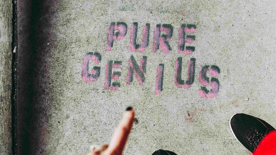 Person pointing to the words "pure genius" on the ground