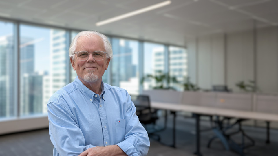 Professor Kerry Back standing in an office with his arms crossed. 