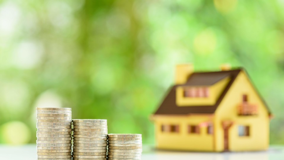 Pile of coins and miniature house