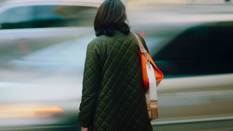 Woman holding shopping bag at a crosswalk
