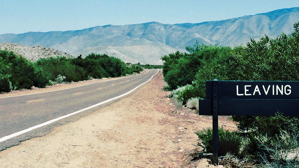 Sign reading leaving on the side of a road leading to a mountain