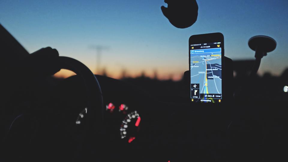 Person navigating in a car using hand free GPS device