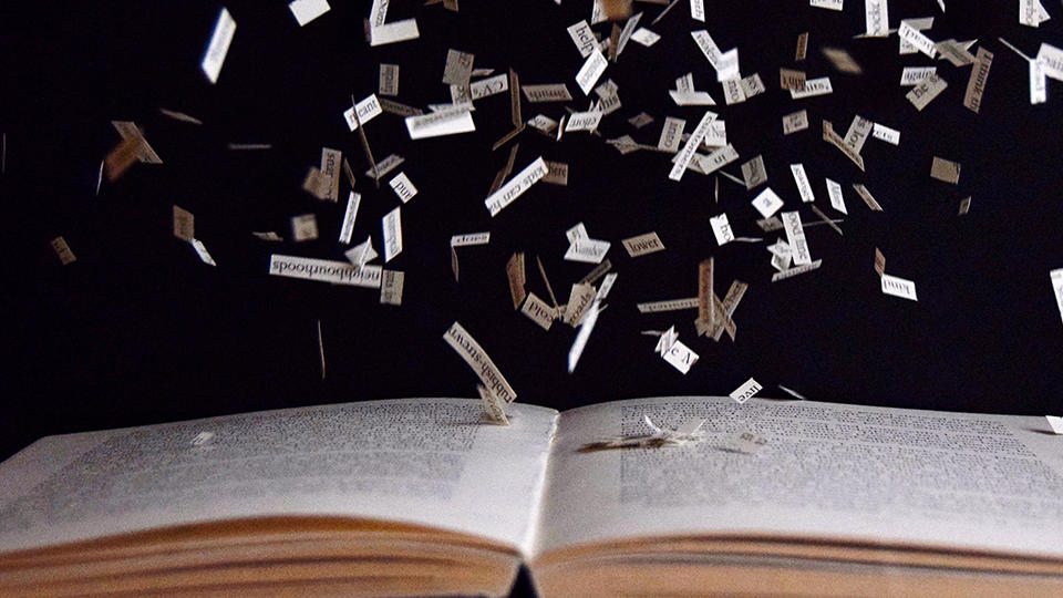 Scraps of paper falling onto an open book