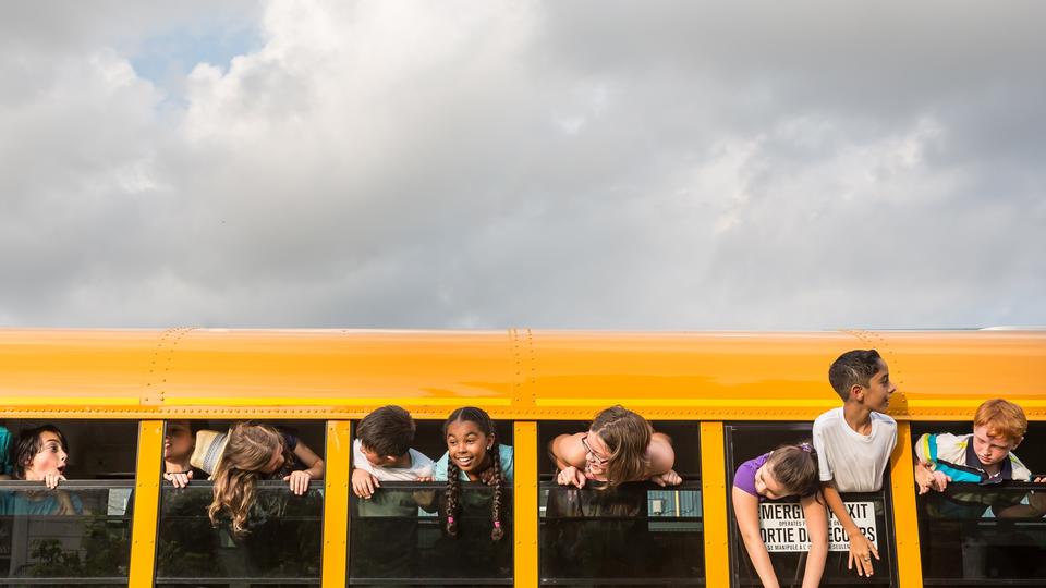 Children looking out of the windows of a school bus