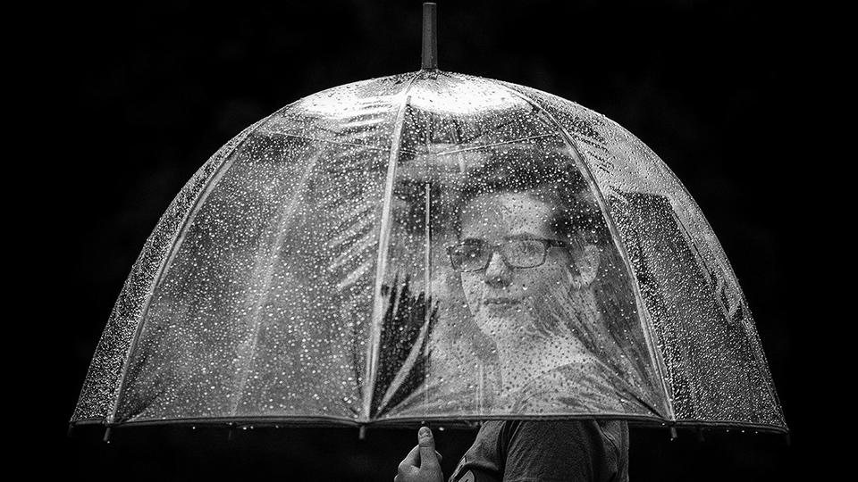 Woman underneath a clear umbrella