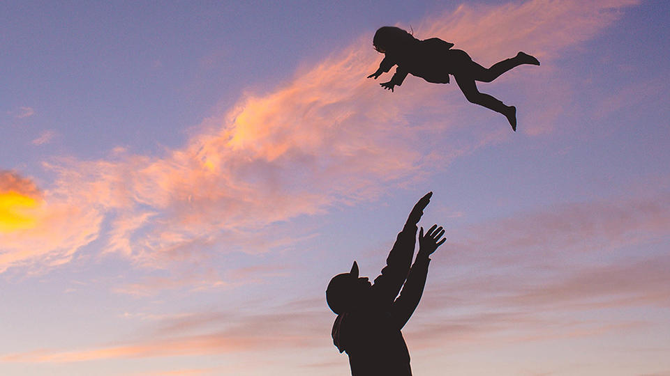 Person throwing a toddler up in the air 